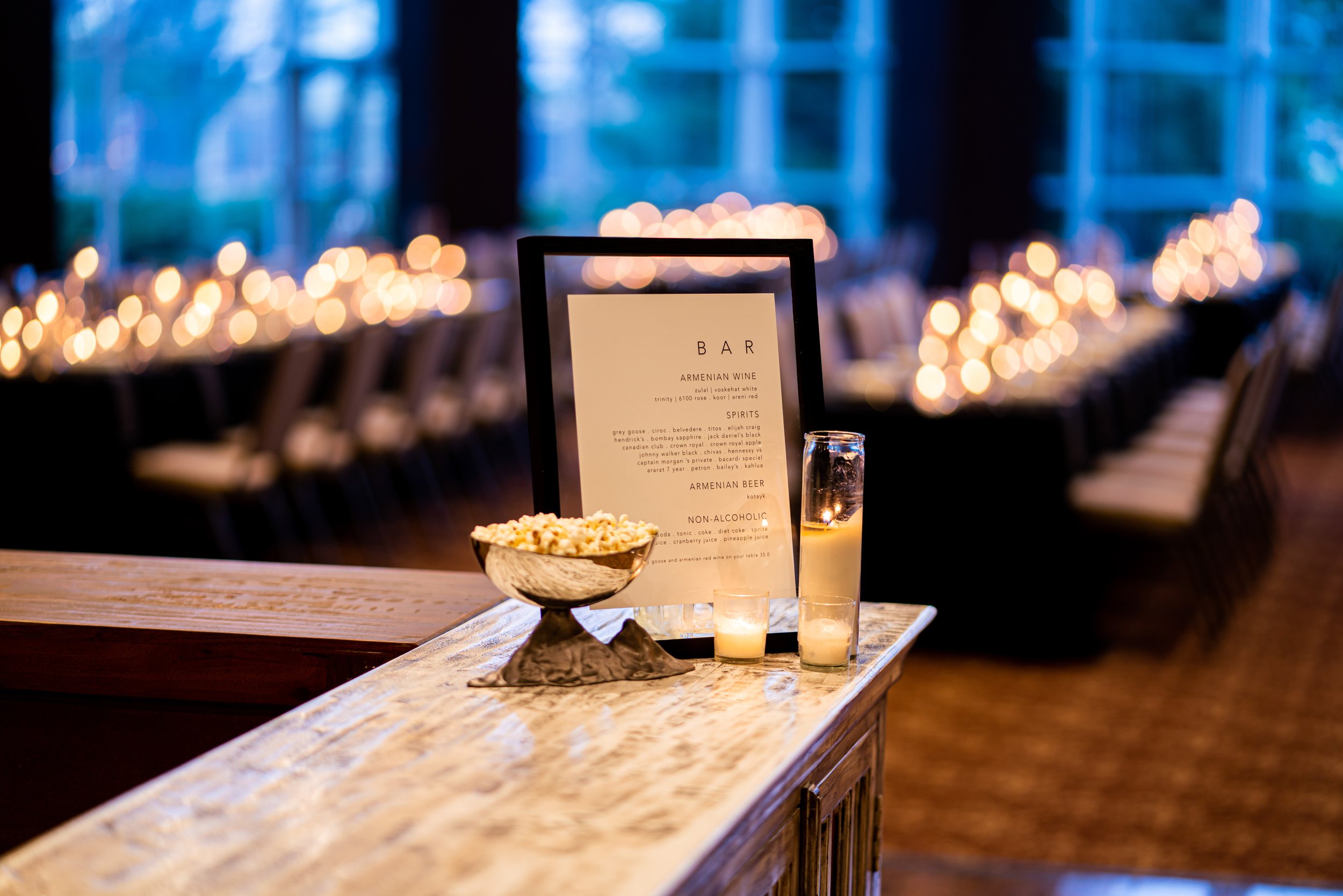 A candlelit bar service with the night's drink menu